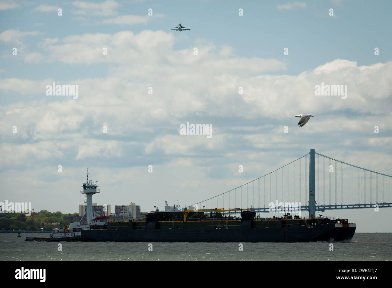 Space shuttle Enterprise, mounted atop a NASA 747 Shuttle Carrier Aircraft (SCA), is seen as it flies over the Verrazano Bridge, Friday, April 27, 2012, in New York. Enterprise was the first shuttle orbiter built for NASA performing test flights in the atmosphere and was incapable of spaceflight. Originally housed at the Smithsonian's Steven F. Udvar-Hazy Center, Enterprise will be demated from the SCA and placed on a barge that will eventually be moved by tugboat up the Hudson River to the Intrepid Sea, Air & Space Museum in June. Stock Photo