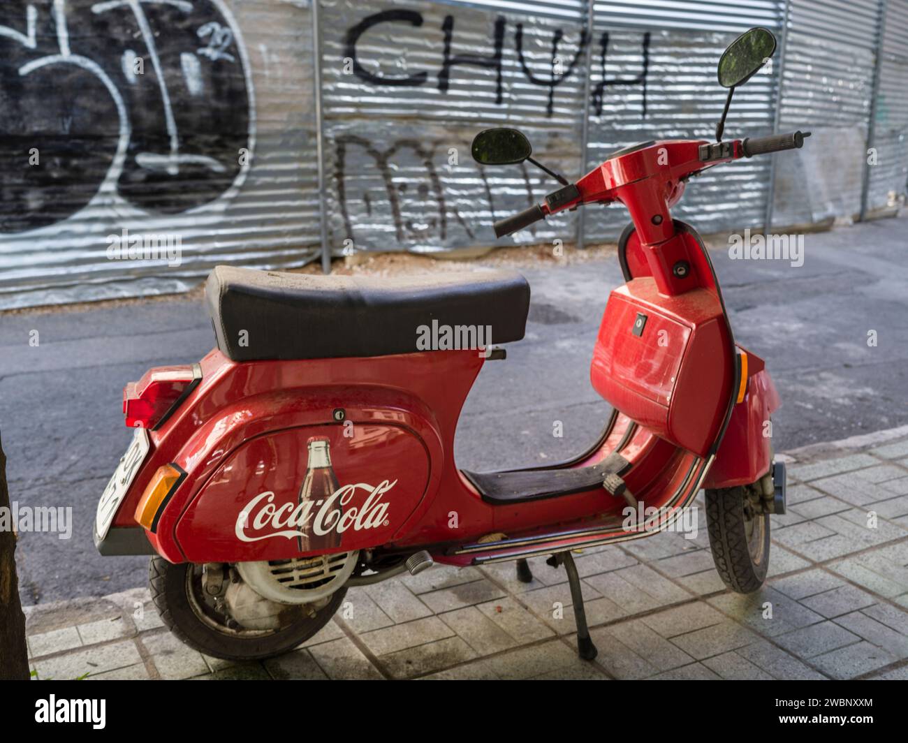 Scooter with Coca-Cola logo parked on a sidewalk in Athens, Greece Stock Photo