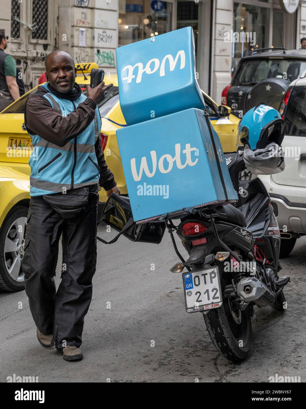 Delivery man with packages on a motorbike on the street in Athens, Greece Stock Photo