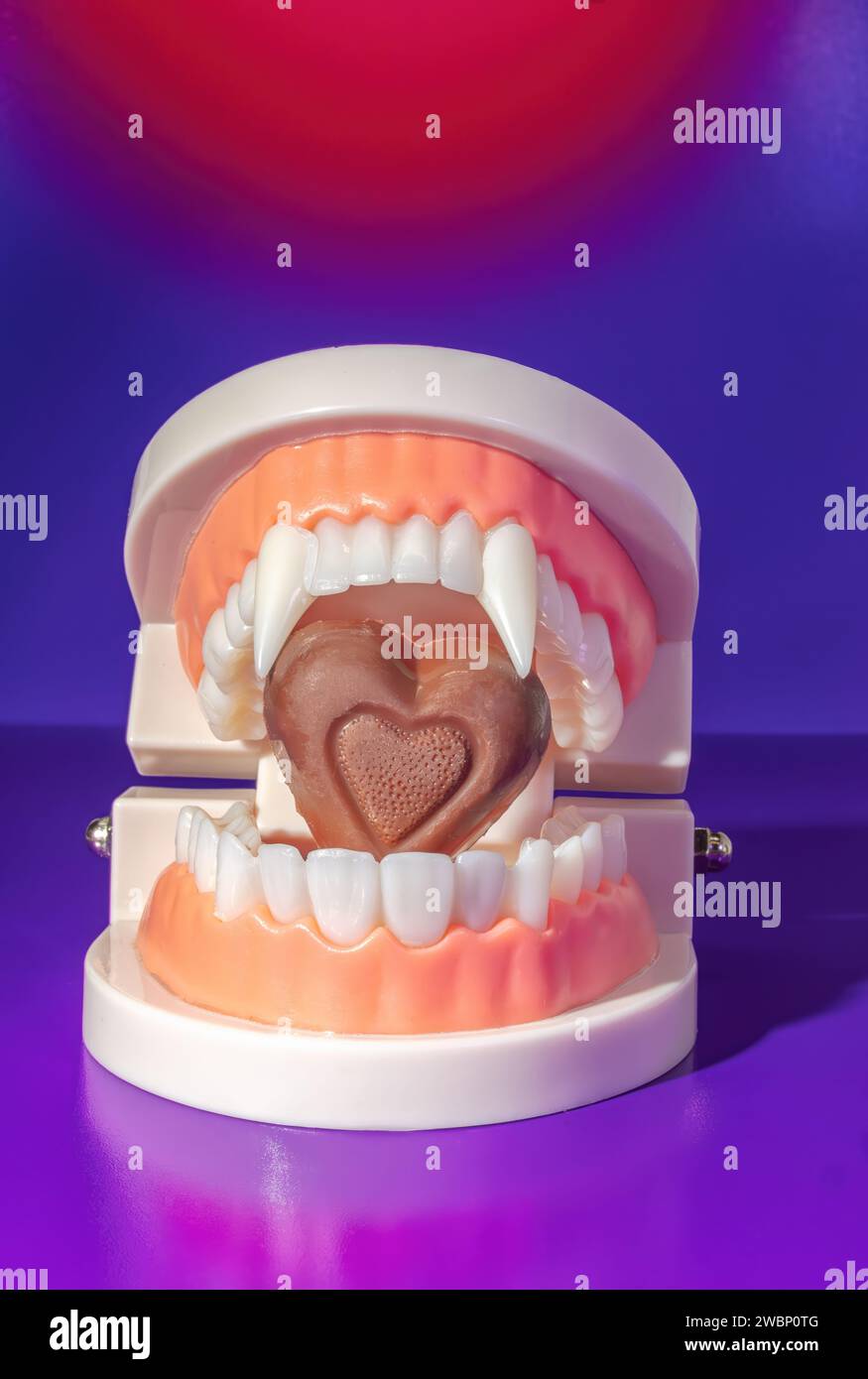 A Vampire Mouth Biting Into Milk Chocolate Heart, Taking a Bite Out of Love Concept Stock Photo
