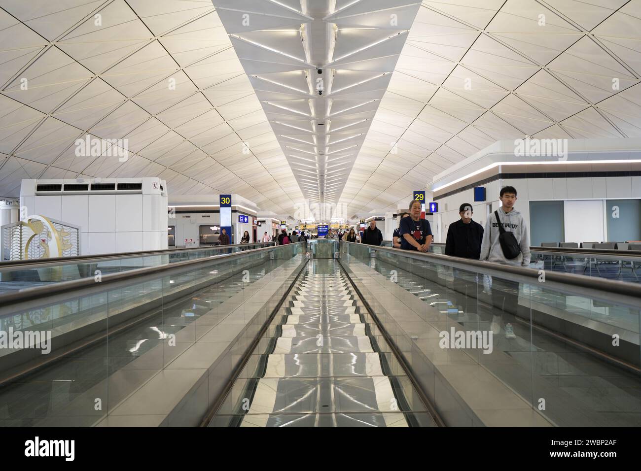 Passengers on automatic moving sidewalk escalator  at Hong Kong international Airport， China Stock Photo