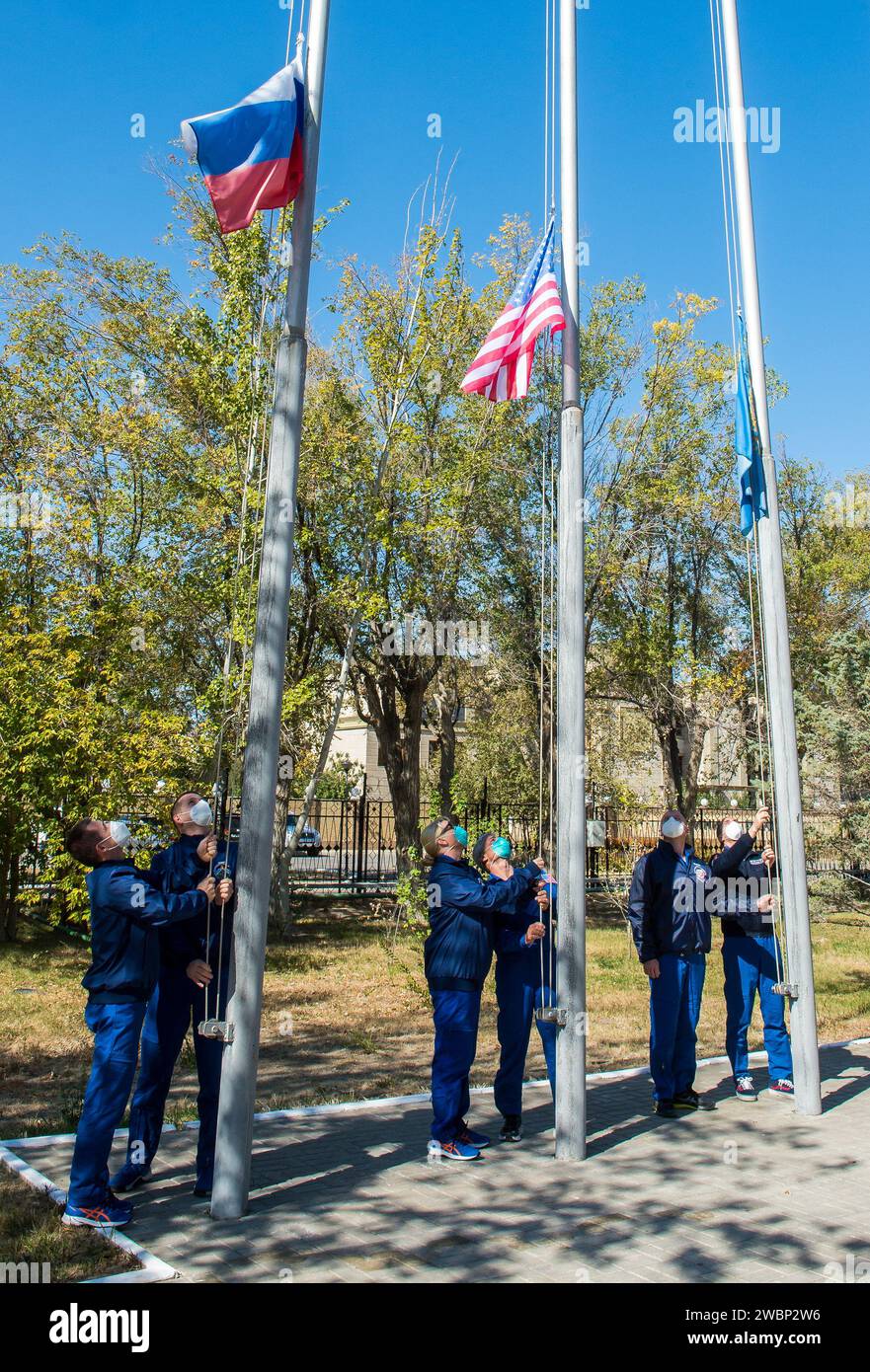The Expedition 64 prime and backup crew members raise the flags of