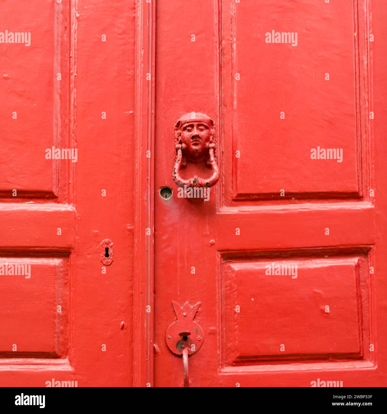 Door knocker on red exterior door of a building in Mykonos Town, Mykonos Island, Greece Stock Photo