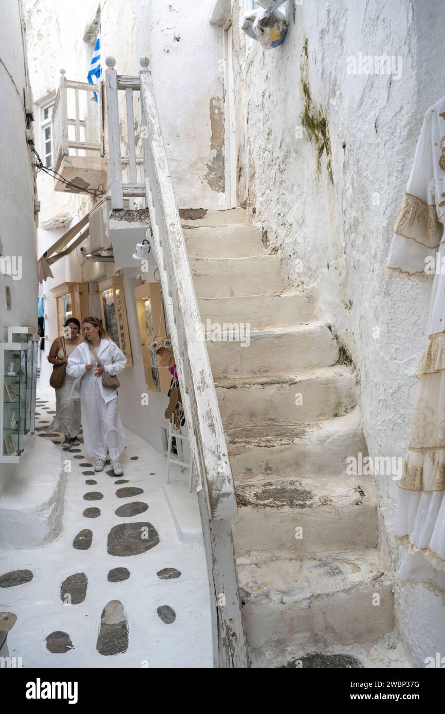 Two women walking amongst shops on a narrow passageway in Mykonos Town, Mykonos Island, South Aegean, Greece Stock Photo