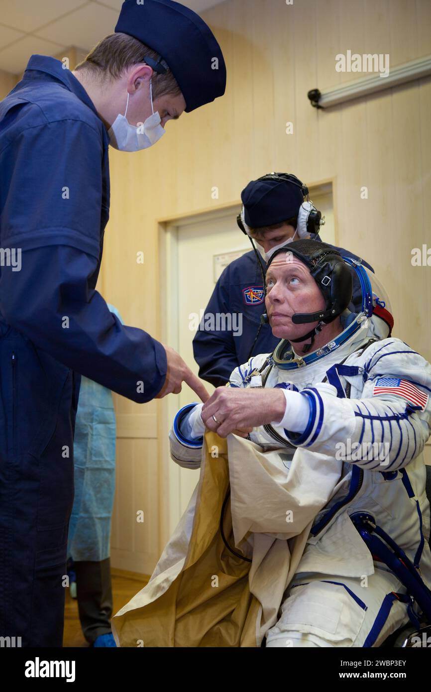 Expedition 28 NASA Flight Engineer Mike Fossum has his Russian Sokol suit prepared for launch by a technician at the Baikonur Cosmodrome in Baikonur, Kazakhstan, Tuesday, June 7, 2011.  Fossum and fellow Expedition 28 crew members Soyuz Commander Sergei Volkov and JAXA (Japanase Aerospace Exploration Agency) Flight Engineer Satoshi Furukawa launched in their Soyuz TMA-02M rocket from the Baikonur Cosmodrome in Kazakhstan the following morning on June 8th. Stock Photo