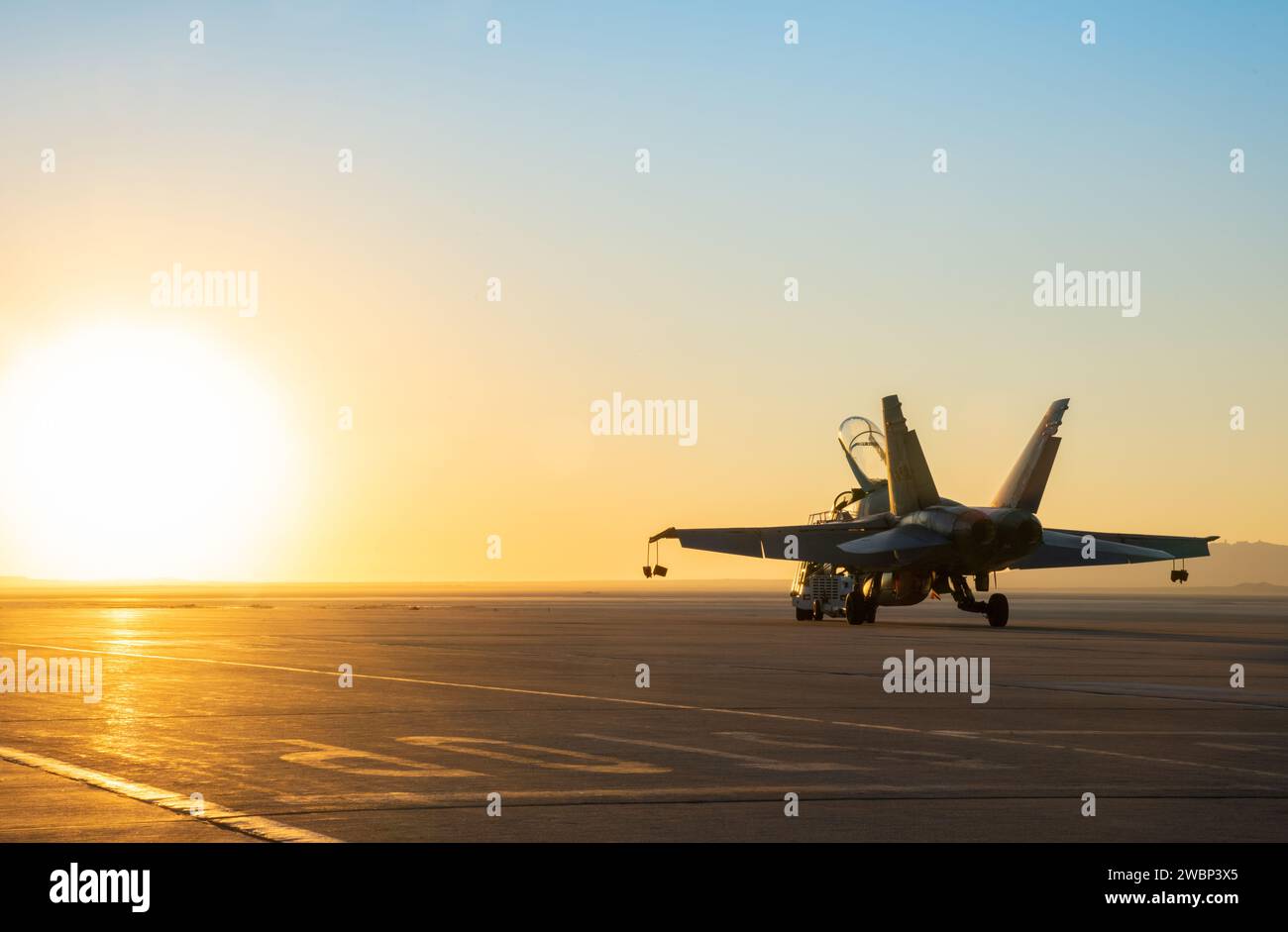 A NASA F/A-18 is towed to the apron at NASA’s Armstrong Flight Research Center in Edwards, California during sunrise over Rogers Dry Lake. The F/A-18 was used to test a transmitter for an air navigation system, called the Airborne Location Integrating Geospatial Navigation System, or ALIGNS. This system, designed to allow pilots to position their aircraft at precise distances to each other, will be critical for acoustic validation efforts of NASA’s next supersonic X-plane, the X-59 Quiet SuperSonic Technology. Stock Photo