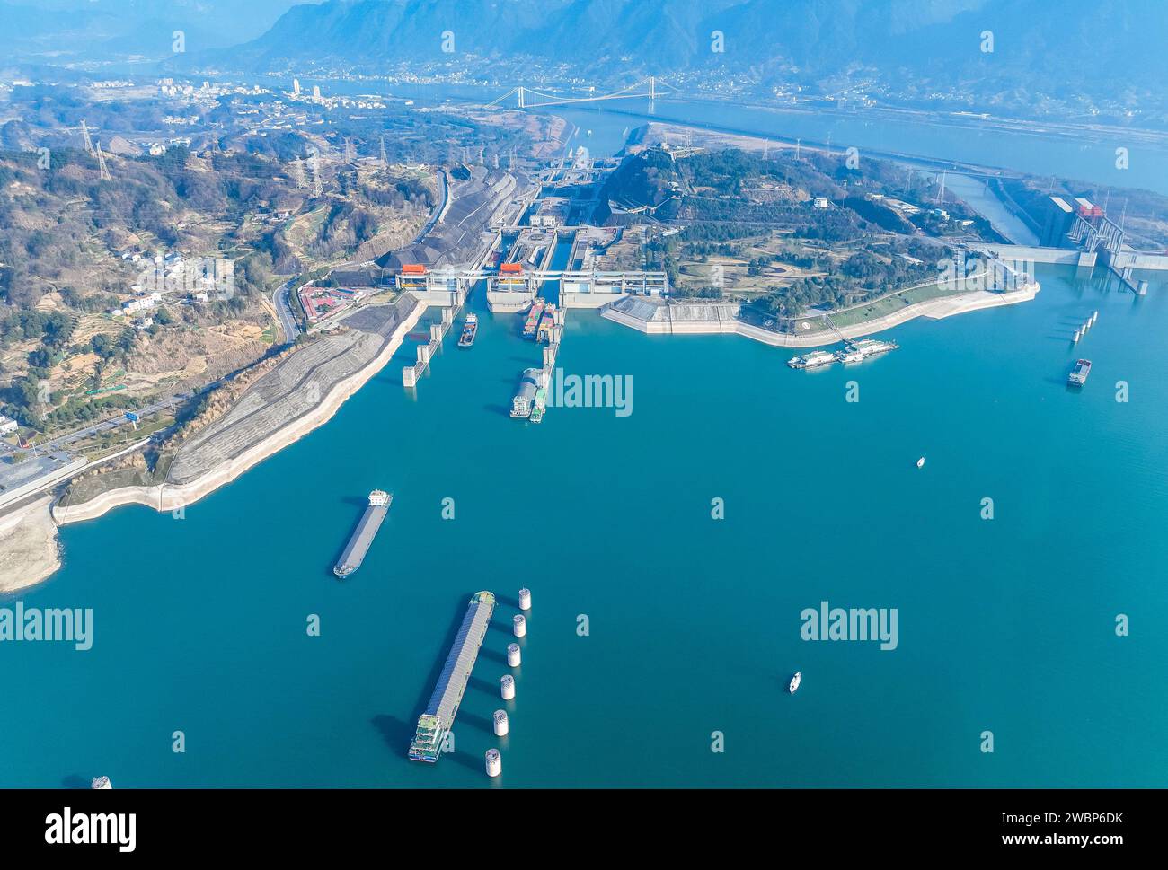 Beijing, China. 11th Jan, 2024. An aerial drone photo taken on Jan. 11, 2024 shows vessels passing through the five-tier ship locks of the Three Gorges Dam in Yichang, central China's Hubei Province. The cargo throughput via the Three Gorges Dam, the world's largest hydropower project on the upper stream of the Yangtze River, reached a record high of 172.34 million tonnes in 2023, up 7.95 percent year on year, according to the China Three Gorges Corporation. Credit: Zheng Jiayu/Xinhua/Alamy Live News Stock Photo