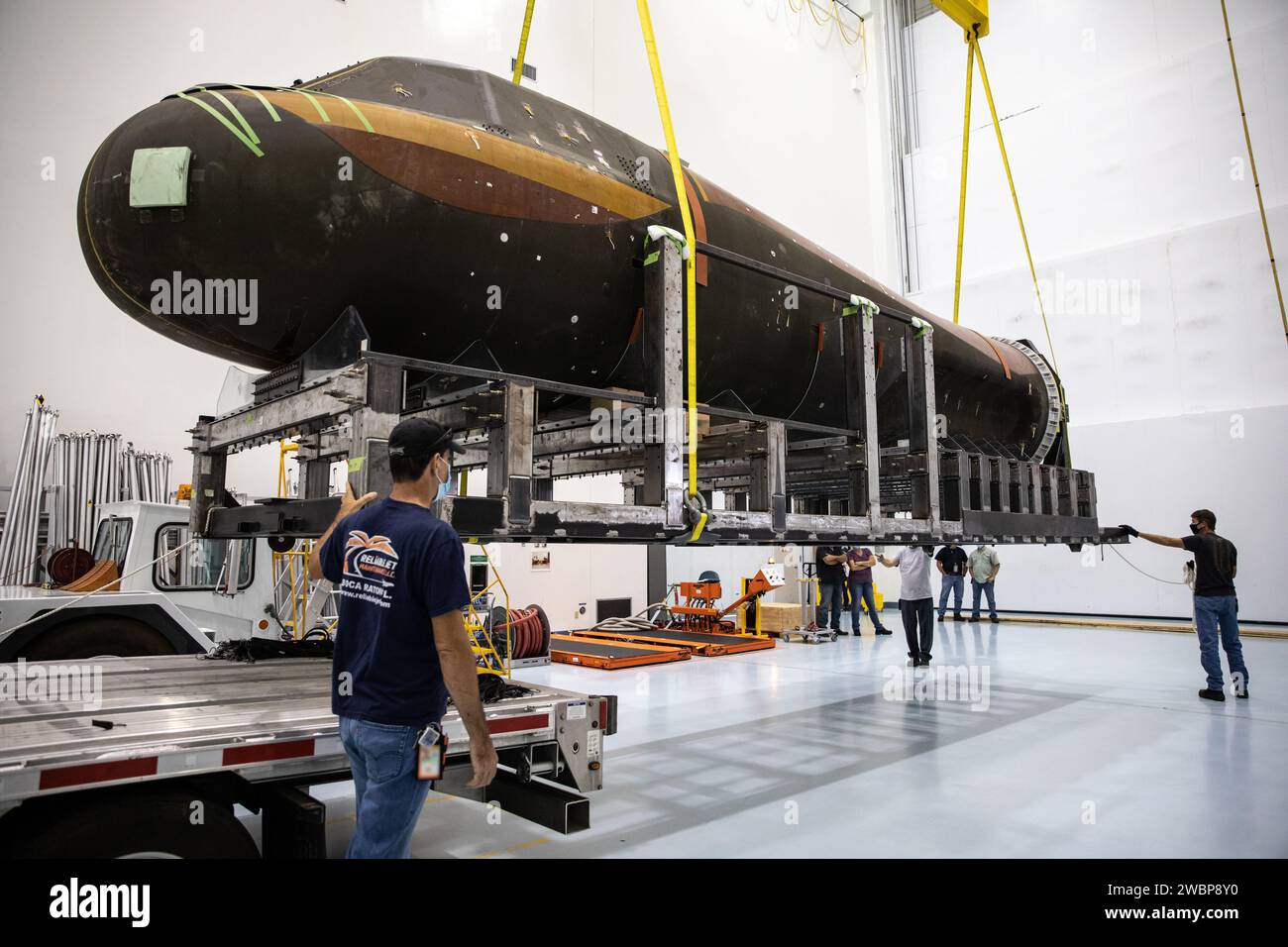 Inside the low bay of the Space Station Processing Facility at NASA’s Kennedy Space Center in Florida, Sierra Nevada Corporation’s (SNC) Dream Chaser pressure test article on its support structure is lifted up by crane from the flatbed truck on June 3, 2020, for its move into the high bay. The test article was shipped from Louisville, Colorado. It is similar to the actual pressurized cabin being used in the Dream Chaser spaceplane for Commercial Resupply Services-2 (CRS-2) missions. NASA selected Dream Chaser to provide cargo delivery, return and disposal service for the International Space St Stock Photo