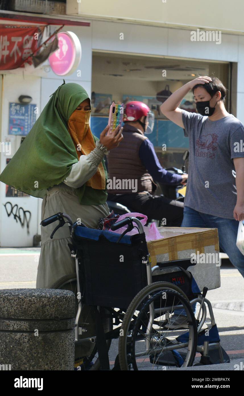 A veiled Indonesian woman taking a selfie in Taipei, Taiwan. Stock Photo