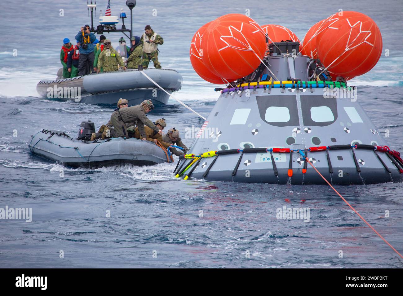 Members of NASA’s Landing and Recovery Team, along with Navy sailors from the USS John P. Murtha (LPD 26) and divers from EOD Mobile Unit 3, MDS Company 3-1, attach tending lines a test version of Orion during Underway Recovery Test-8 off the coast of California. During the test, the team practiced to ensure recovery procedure timelines are validated as NASA plans to send Artemis I around the Moon and splashdown in the Pacific Ocean. Stock Photo