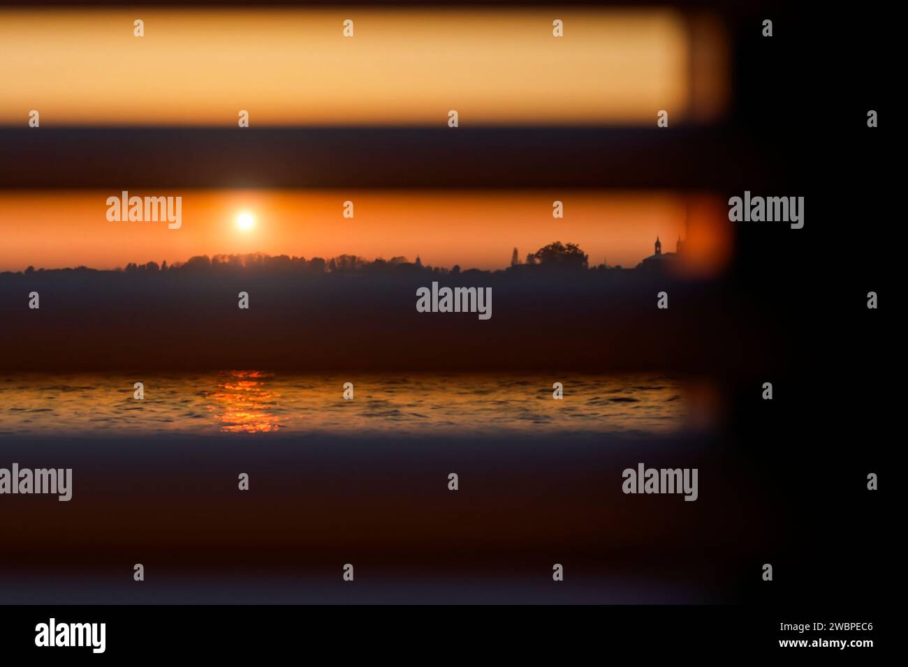 The setting sun shines through the closed horizontal blinds Stock Photo ...