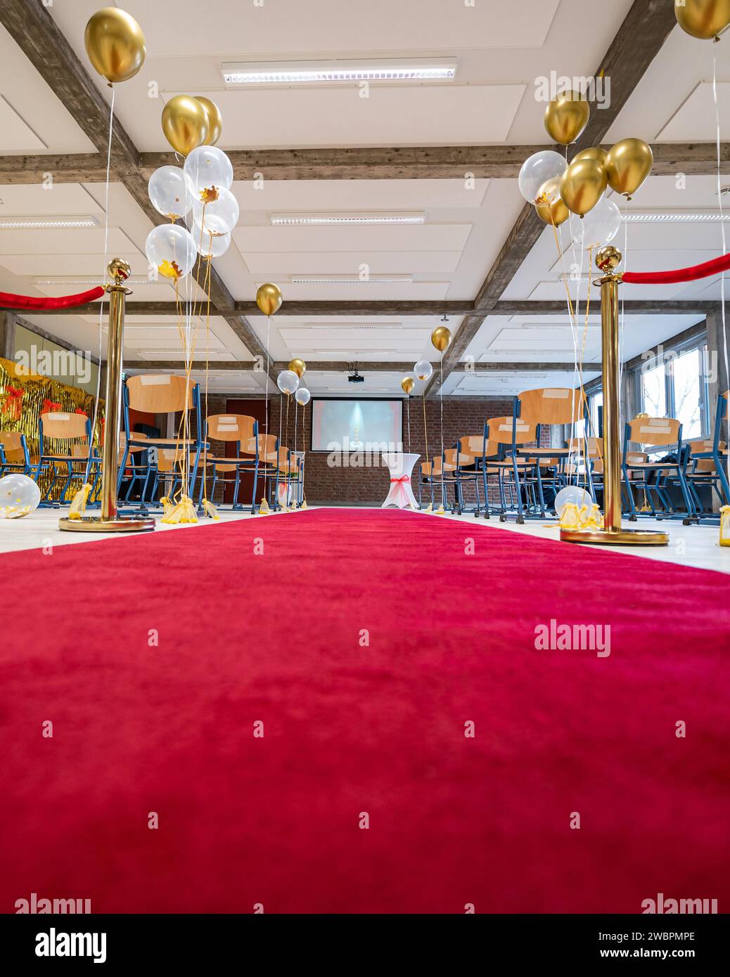 German Abitur Graduation party room decoration with Balloons and Award sculptures red carpet preparations for surprise party Stock Photo