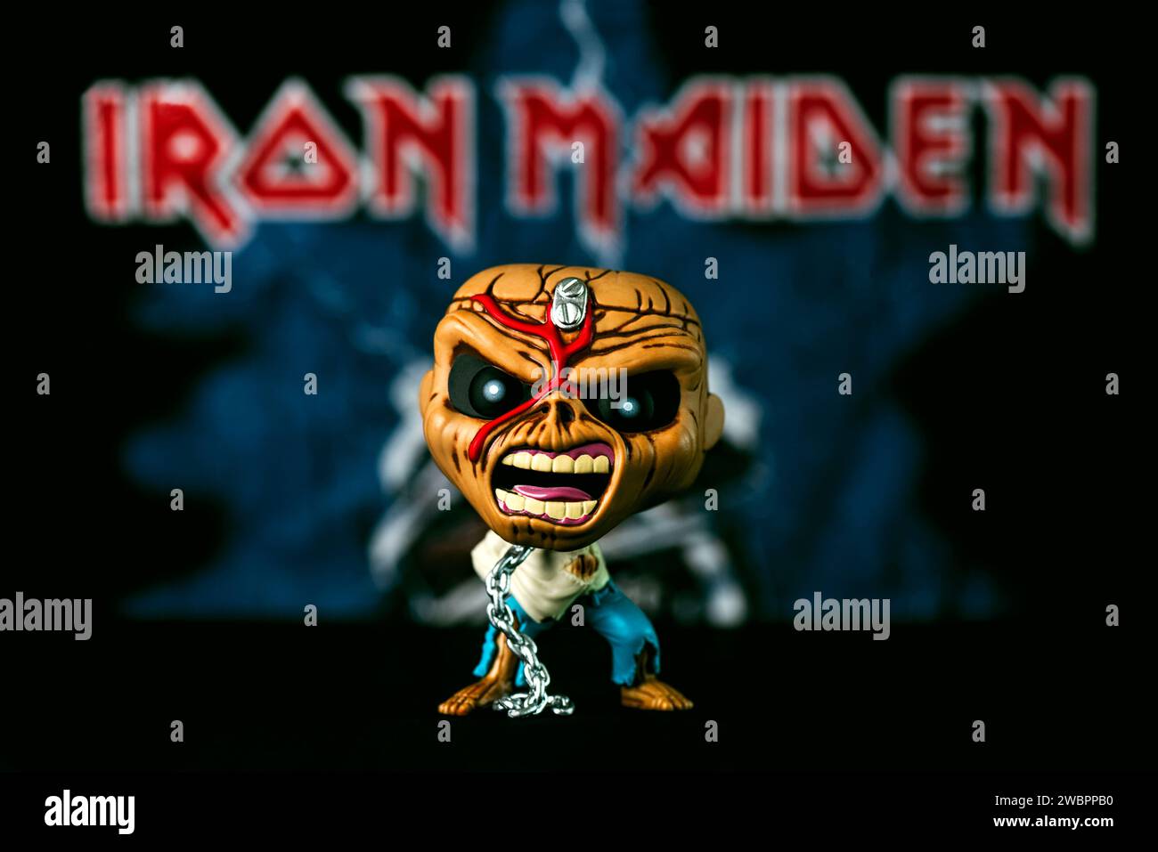 Funko POP vinyl figure of Piece of mind Eddie mascot of the British heavy metal band Iron Maiden in front of Iron Maiden poster. Illustrative editoria Stock Photo