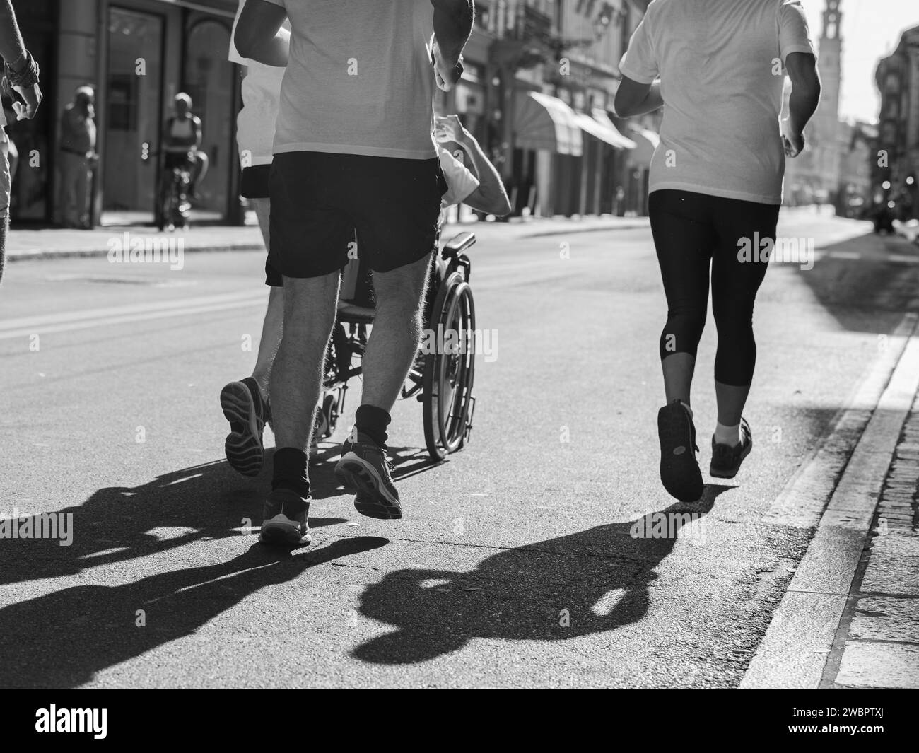 Athletes Runners and Boy in a Wheelchair during Sport Marathon. Stock Photo