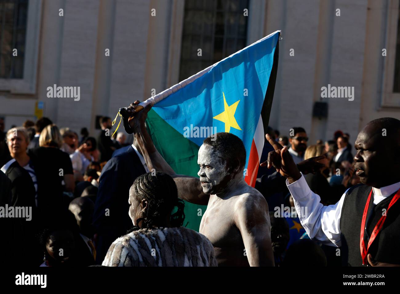 A faithful waving a South Sudanese flag waits for the start of a consistory in St. Peter Square at the Vatican, September 30, 2023. Stock Photo