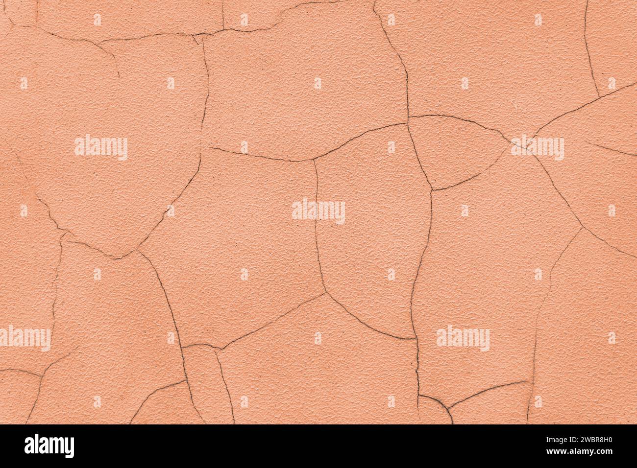 Old stucco plaster surface with cracks, close up grunge texture of orange painted cement, concrete wall texture background. Wallpaper, backdrop, archi Stock Photo