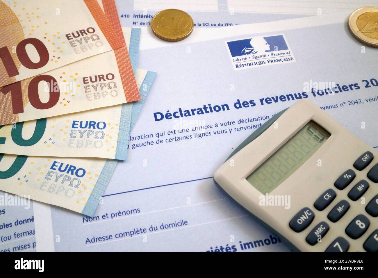 A calculator and some euro coins and banknotes on the top of a French