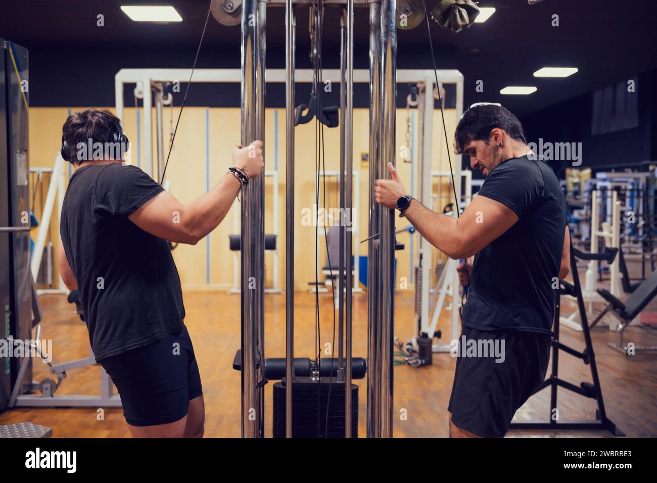 Two men are intensely focused on lifting weights at the gym Stock Photo