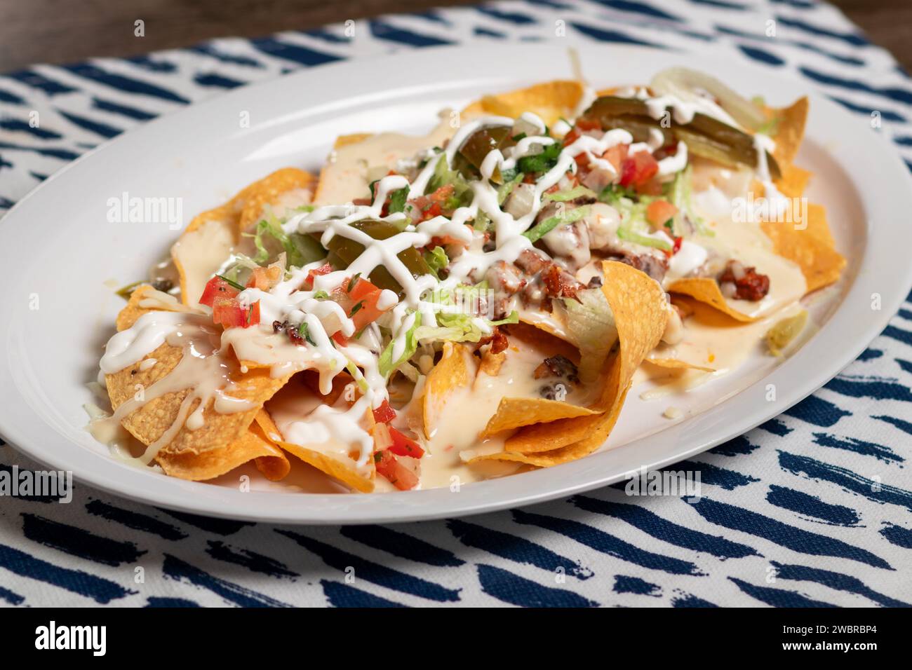 Carne Asada Nachos with sour cream, queso and tomatoes Stock Photo Alamy