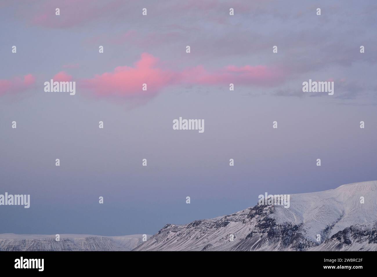 Snowy mountain ridge under cloudy sky Stock Photo