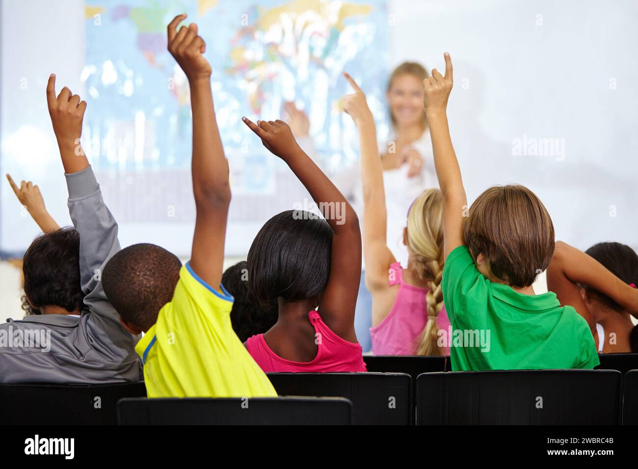 Back of children, teacher and raise hands for questions, education or