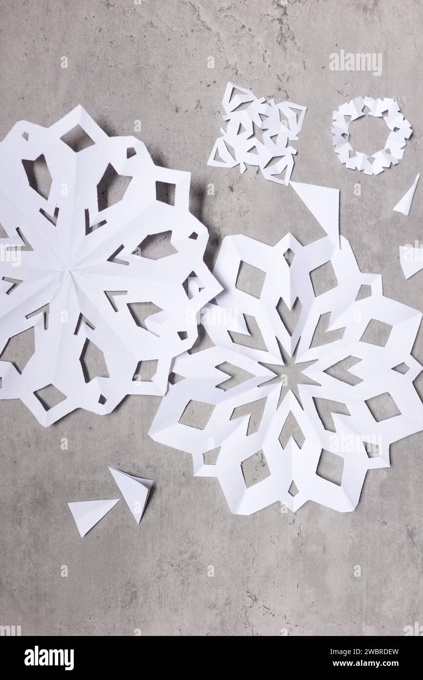 flat lay of white paper snowflakes and paper scraps Stock Photo
