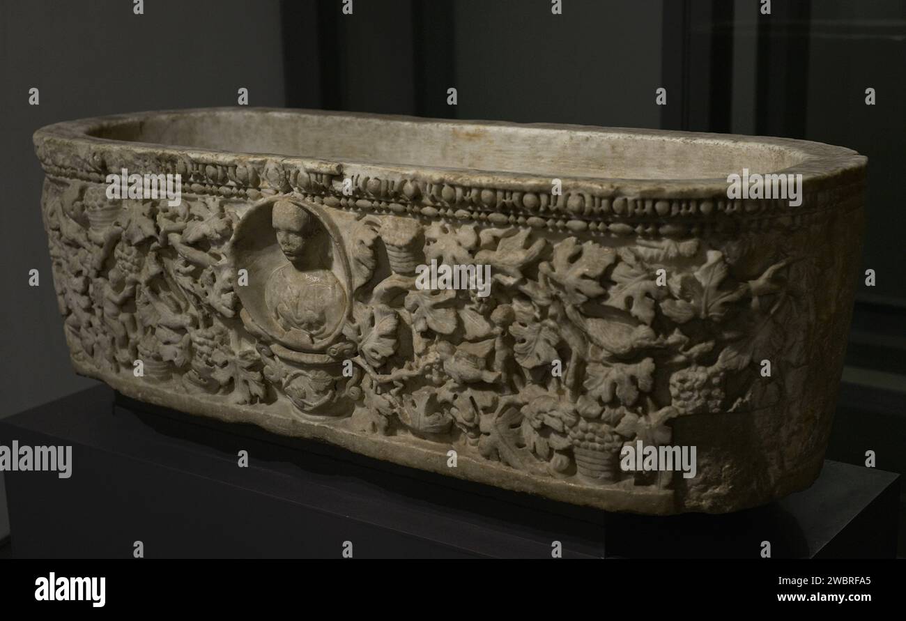 Sarcophagus of the Grape Harvest. In the shape of a bathtub or grape press, its decoration depicts a vineyard. The central medallion shows a bust of the deceased, apparently a young girl. White marble. 3rd century AD. Size: 1,18 m. (length), 0,45 m. (width) and 0,35 m. (height). From the ancient parish of Castanheira do Ribatejo. Found in Vila Franca de Xira (Lisbon district, Portugal) in 1944. National Archaeology Museum. Lisbon, Portugal. Stock Photo