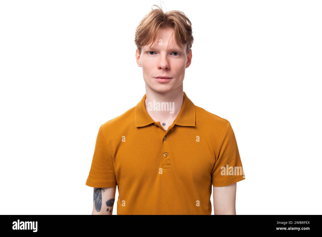 young serious guy with short red hair dressed in a summer orange t-shirt Stock Photo
