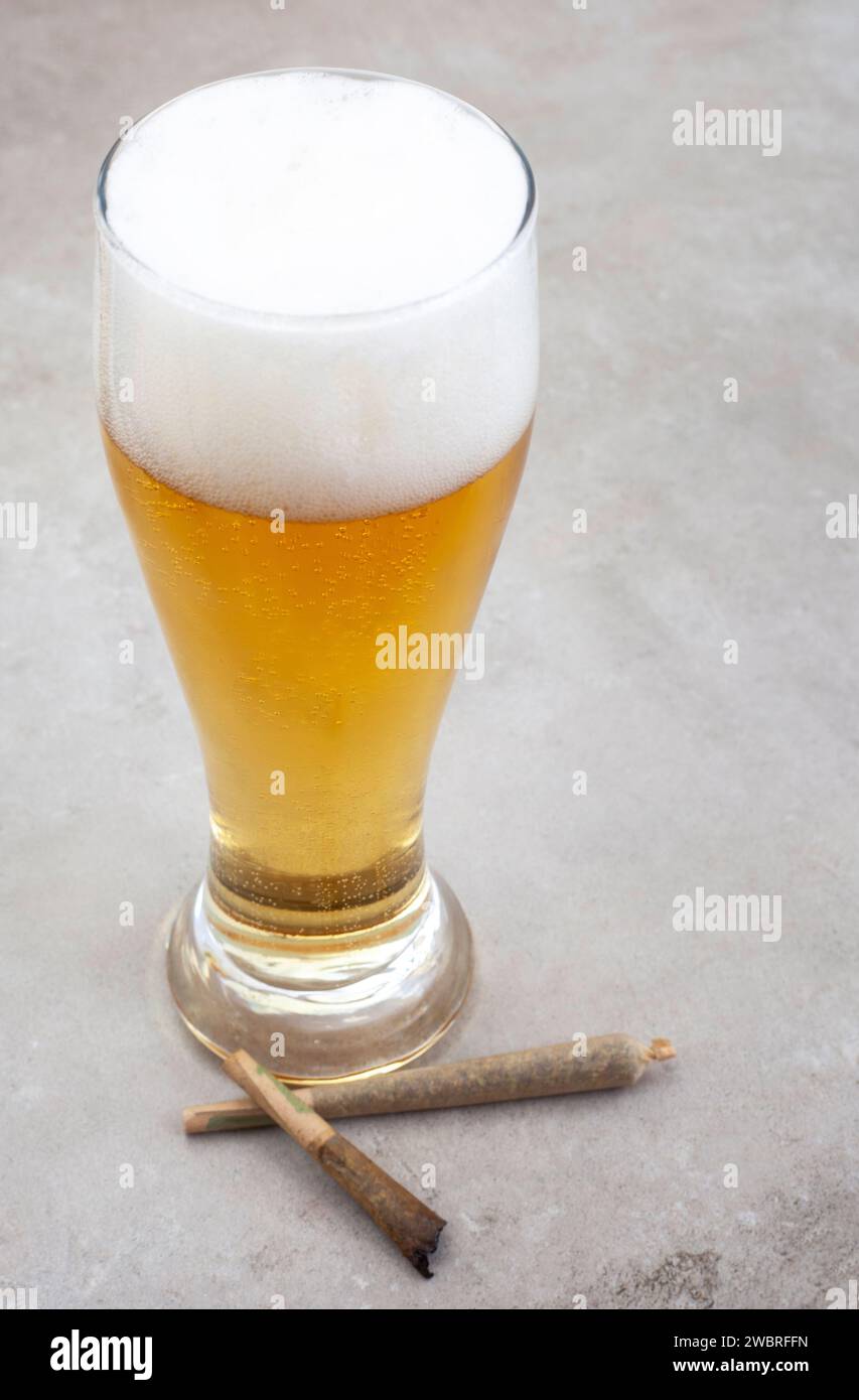 Marijuana joint with glass of beer on grey grunge surface Stock Photo