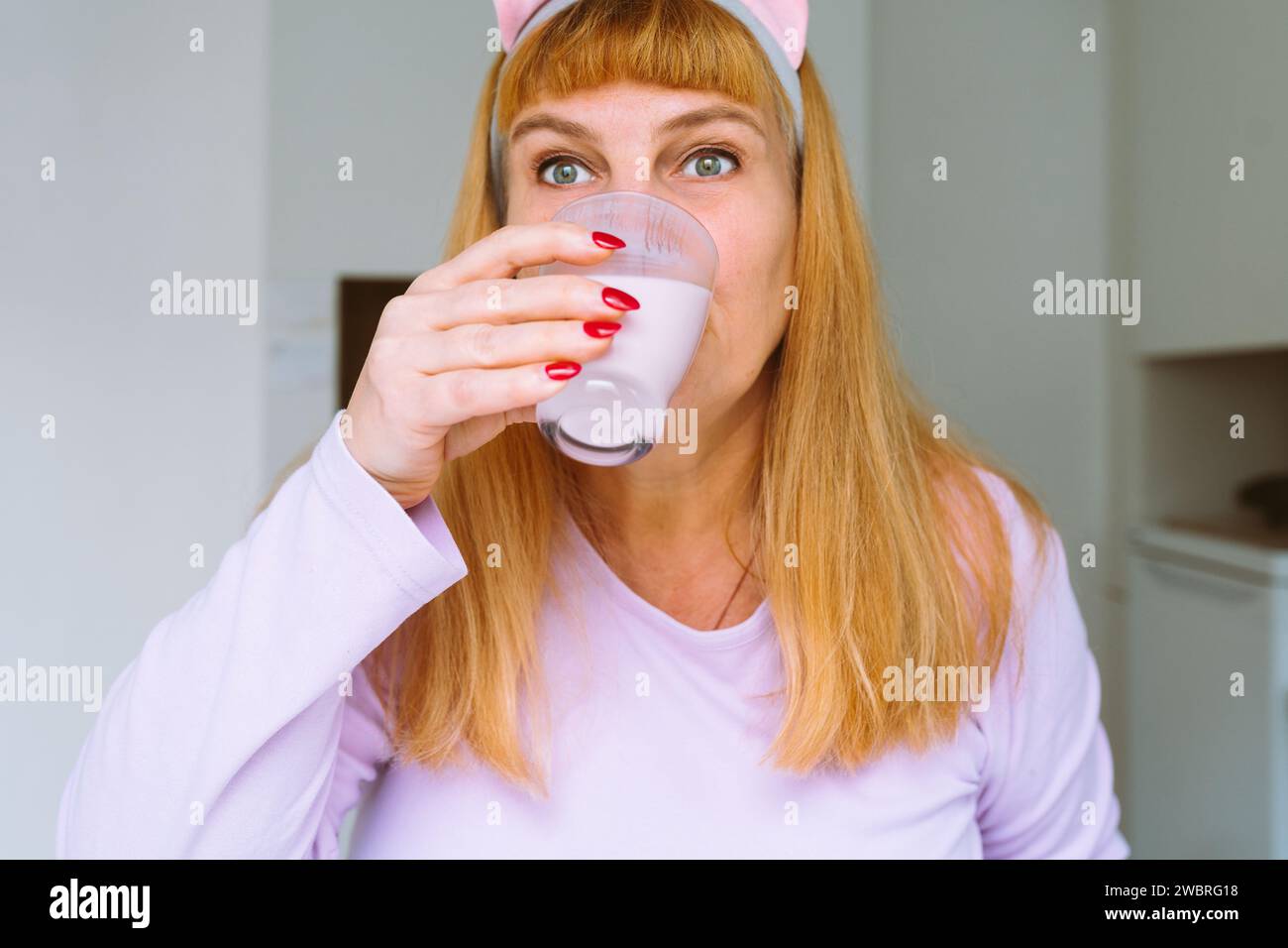 Middle aged woman drinking yogurt Stock Photo