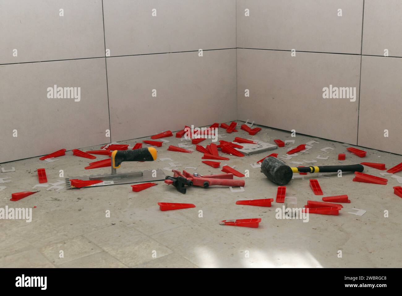 Plastic tile leveling system, notched trowel and rubber hammer for