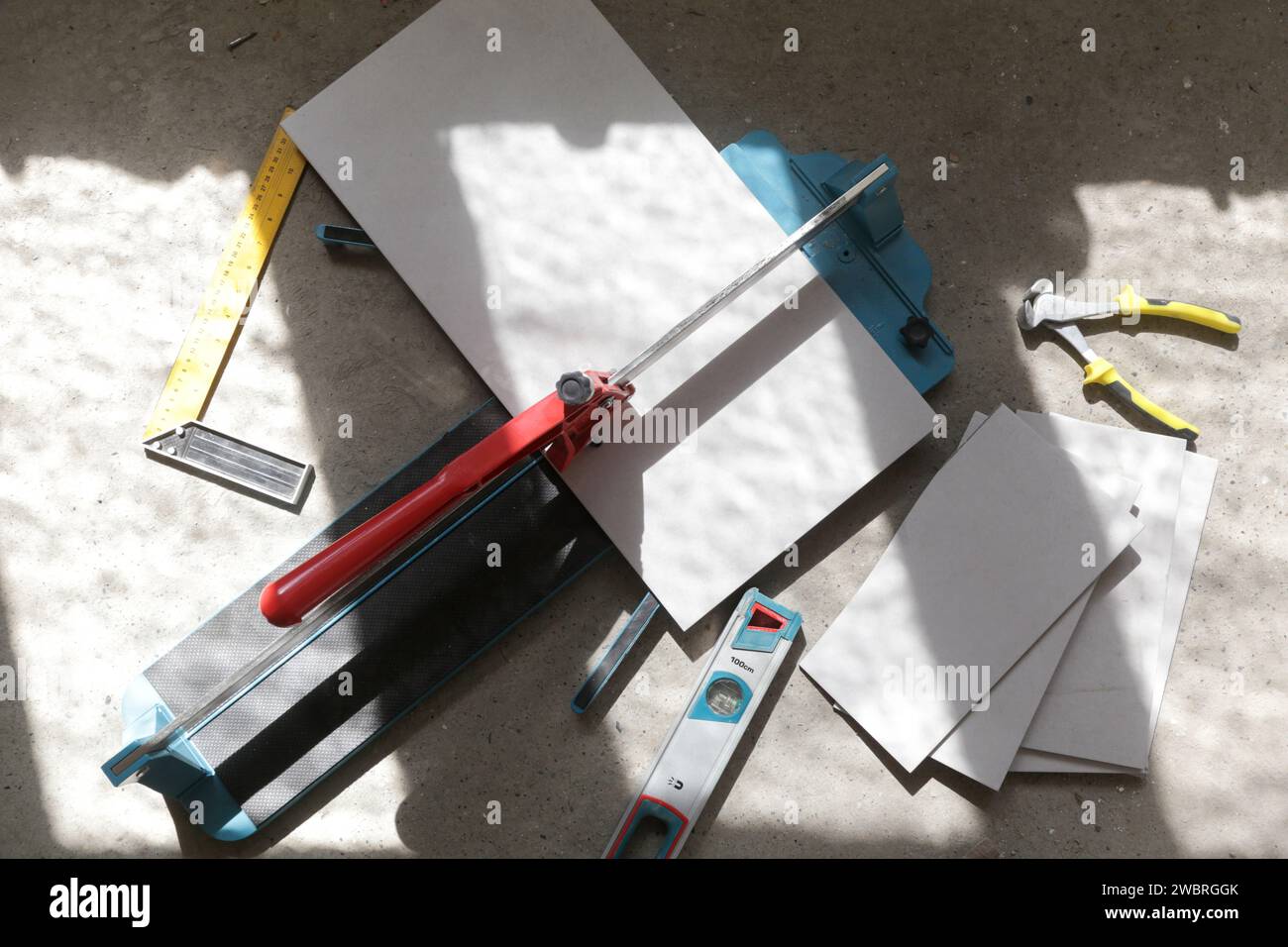 Cutingt tiles with a standard manual tile cutter. Process of