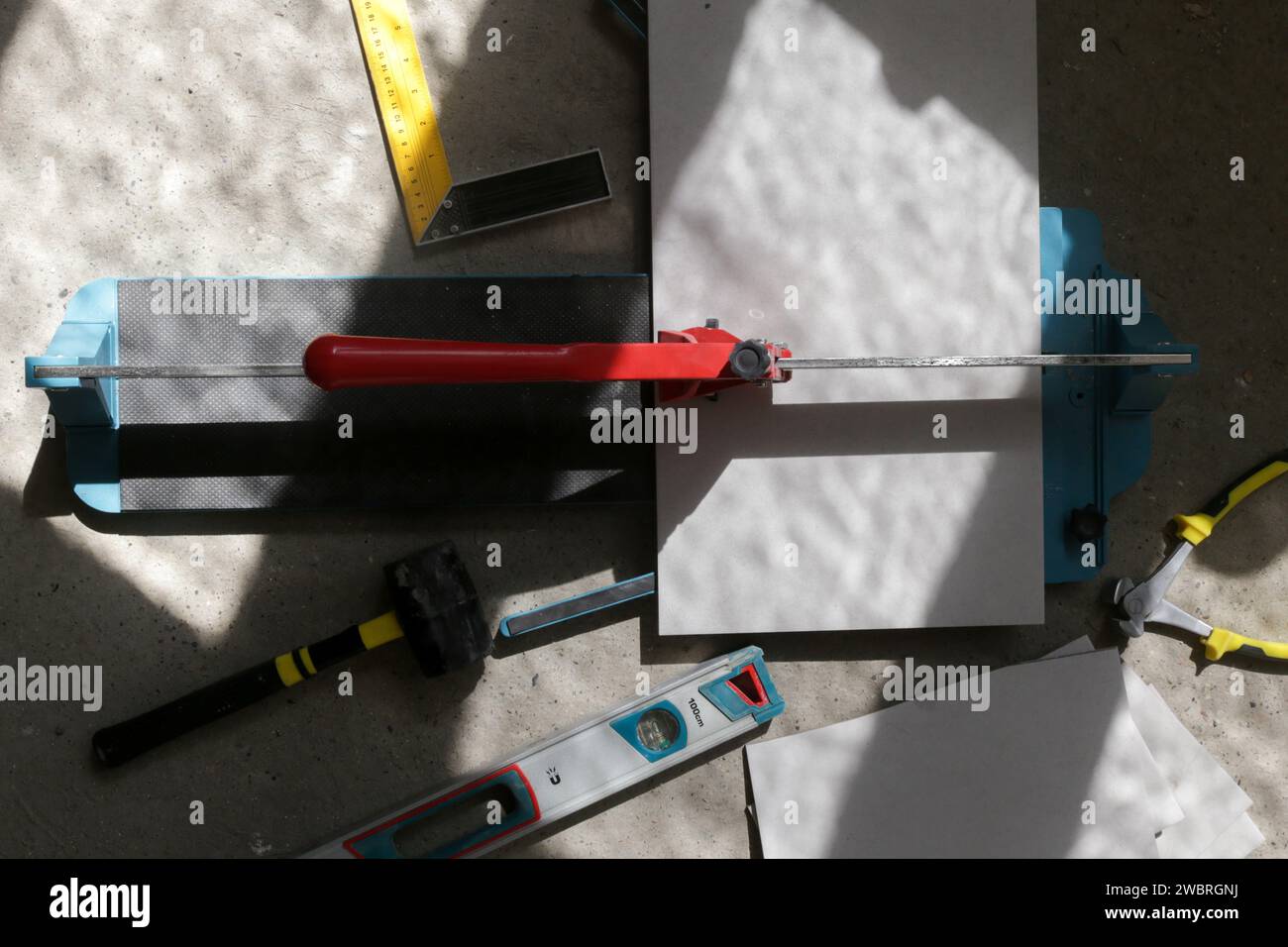 Cutingt tiles with a standard manual tile cutter. Process of