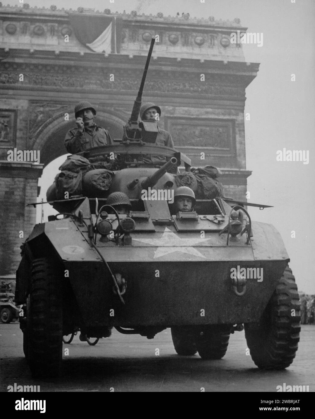 PARIS, FRANCE - August 1944 - US Army soldiers in an M8 light armored car driving down the Champs Elysees in central Paris during the Liberation of Pa Stock Photo