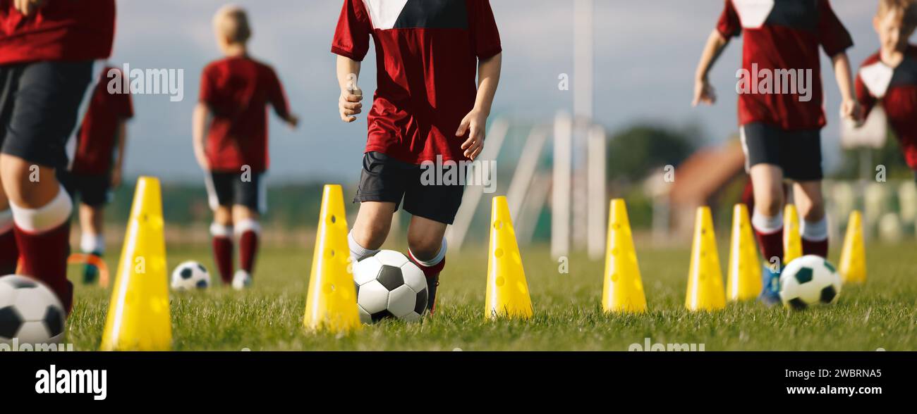 Professional Soccer Coaching. Soccer Drills in Dribbling Ball Between Practice Cones. Young Players Kicking Balls and Improving Ball Mastery Skills. F Stock Photo