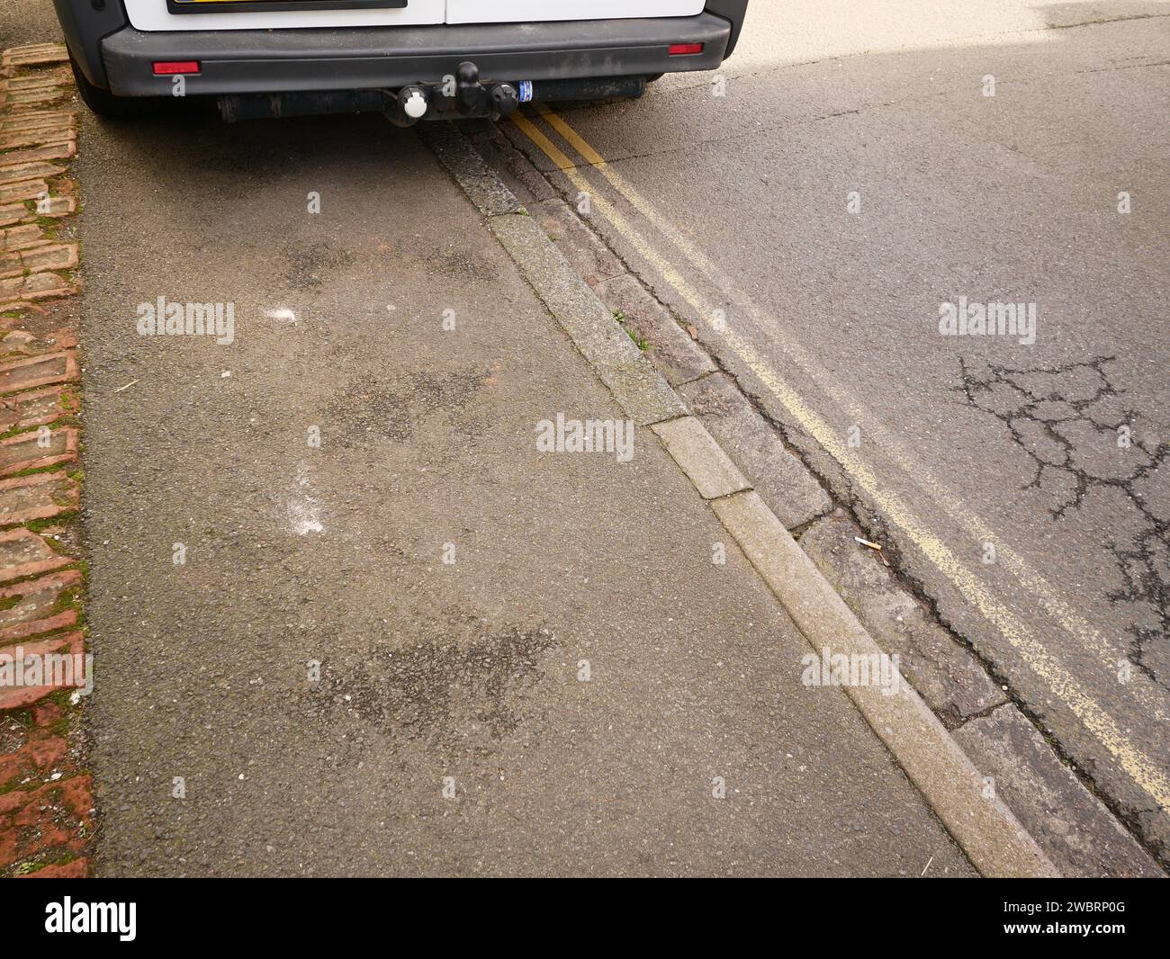 Vehicle parked over pavement causing an obstruction and blocking pedestrian access. Stock Photo