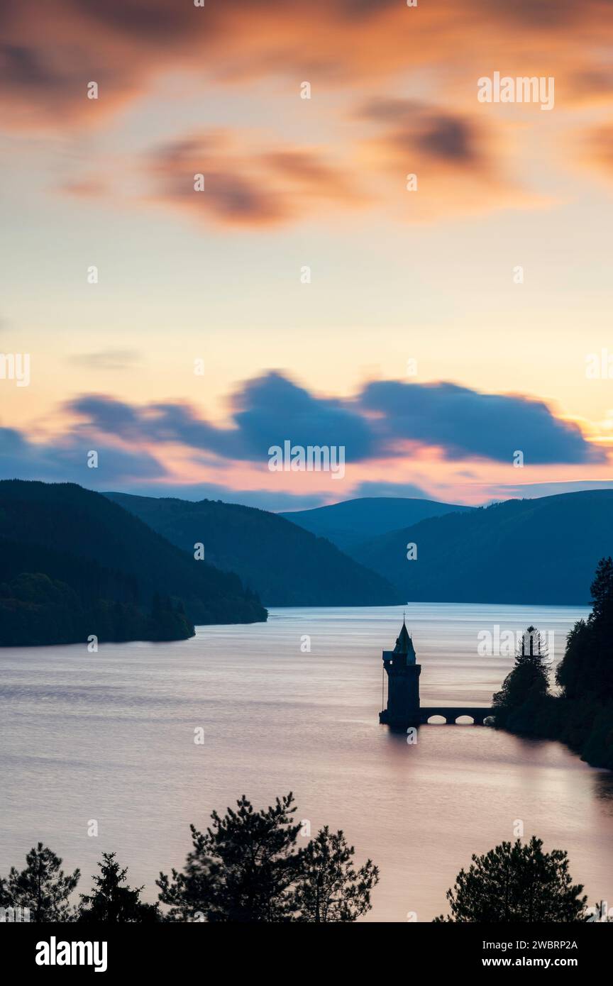 Lake Vyrnwy, located in mid Wales, an area of outstanding natural beauty, at sunset. The orange sky is reflected in the calm water of the lake Stock Photo