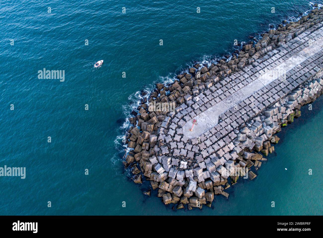 drone view of a boat near a concrete block breakwater. Vila Praia de Ancora, Portugal Stock Photo