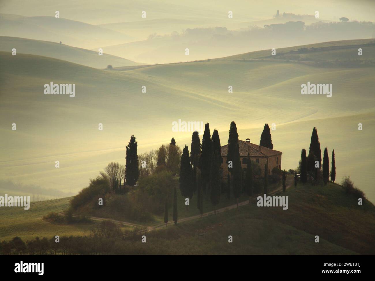 A farmhouse on top of a hill in a typical landscape in Tuscany, Italy. Stock Photo