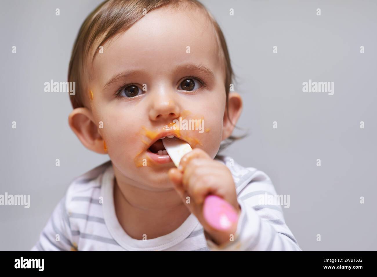 Spoon, food and baby eating in a studio for organic, healthy or