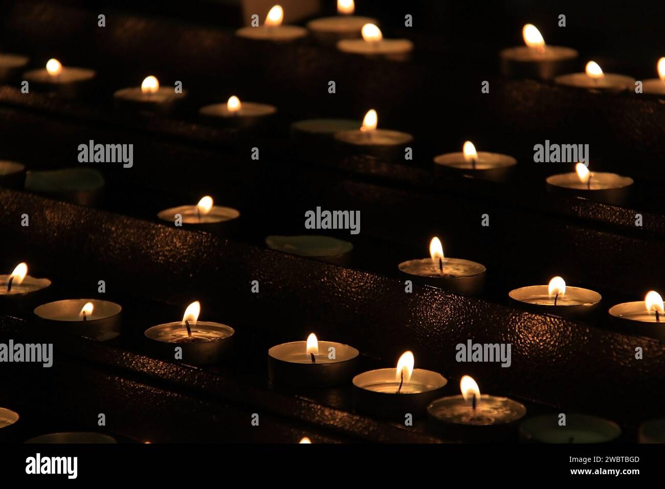 Many candles lit inside a Catholic church Stock Photo Alamy