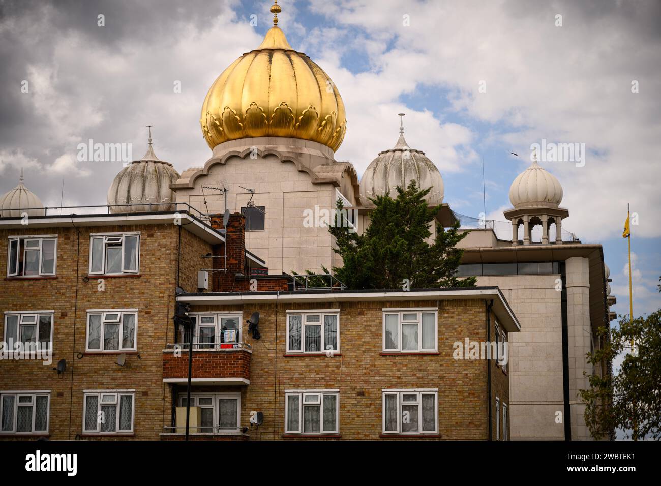 29th August, 2022: Southall, in the borough of Ealing in West London, is home to the largest Punjabi community outside the Indian subcontinent. It has become a hub of Asian culture in the UK, often referred to as Little India. The photograph shows a housing estate with the Gurdwara Sri Guru Singh Sabha temple in the background. Stock Photo