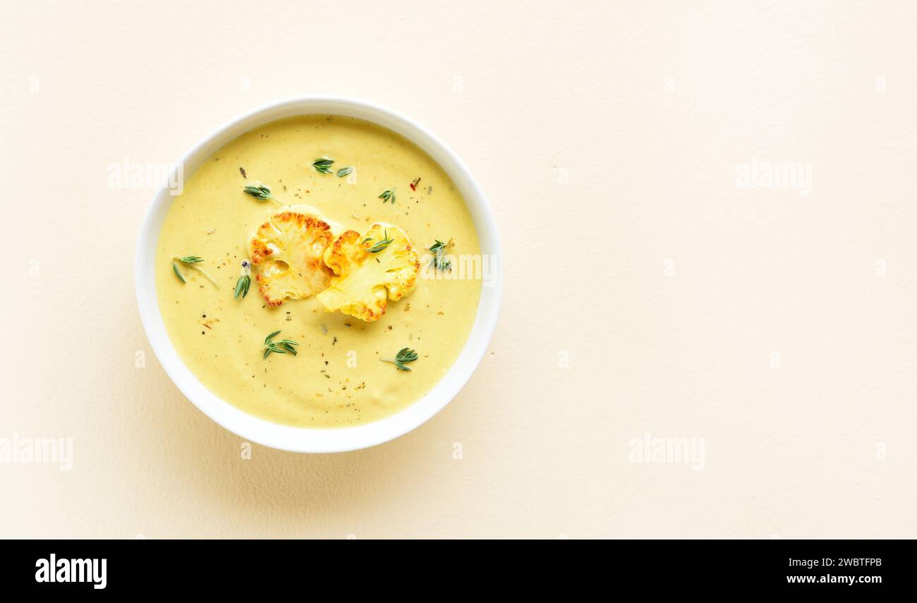 Cauliflower cheese soup in bowl over light background with copy space. Vegetarian or healthy diet food concept. Top view, flat lay Stock Photo