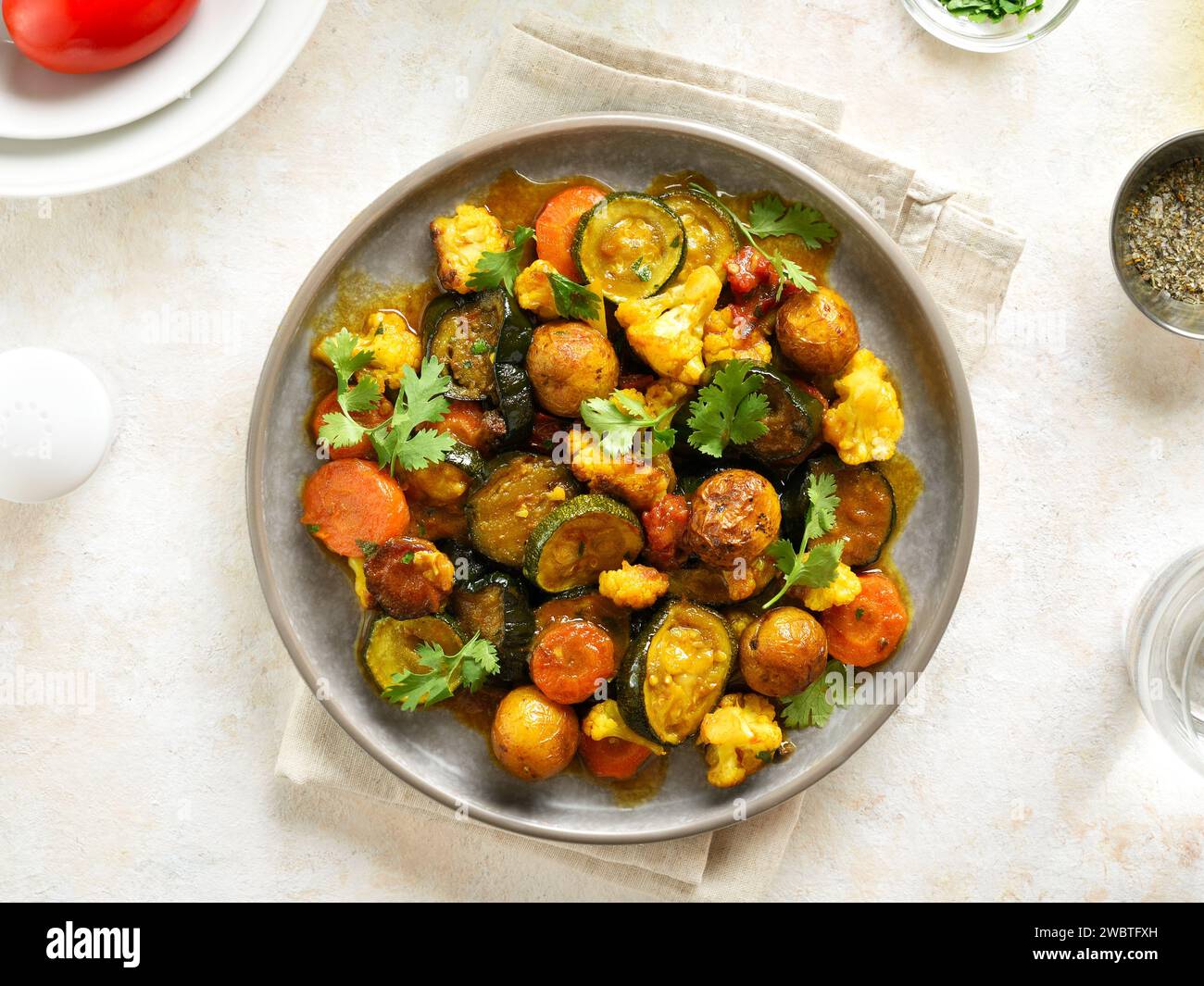 Vegetarian stew with mixed vegetables on plate over light background. Colorful mix of seasonal vegetables for comfort eating. Top view, flat lay Stock Photo