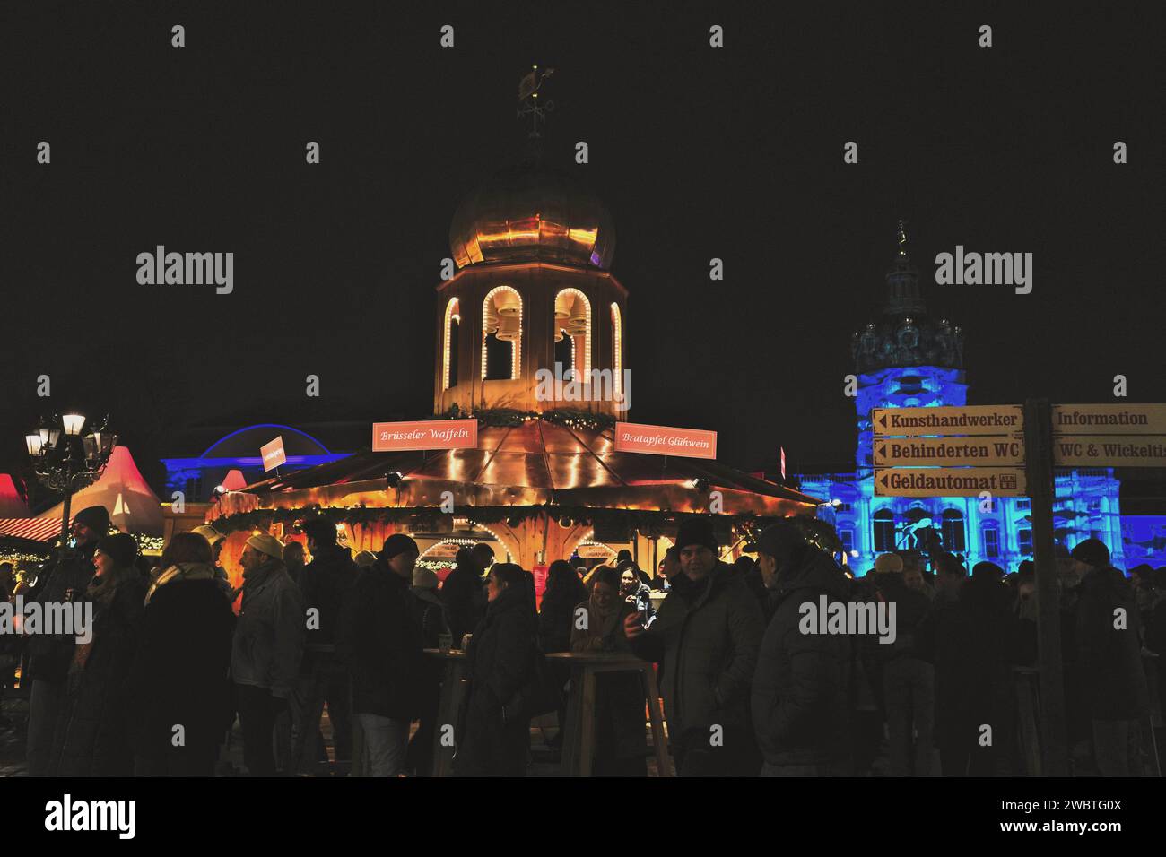 People enjoying Glühwein, waffels, sausages and other food at Christmas Market at Charlottenburg Palace in Berlin, Germany Stock Photo