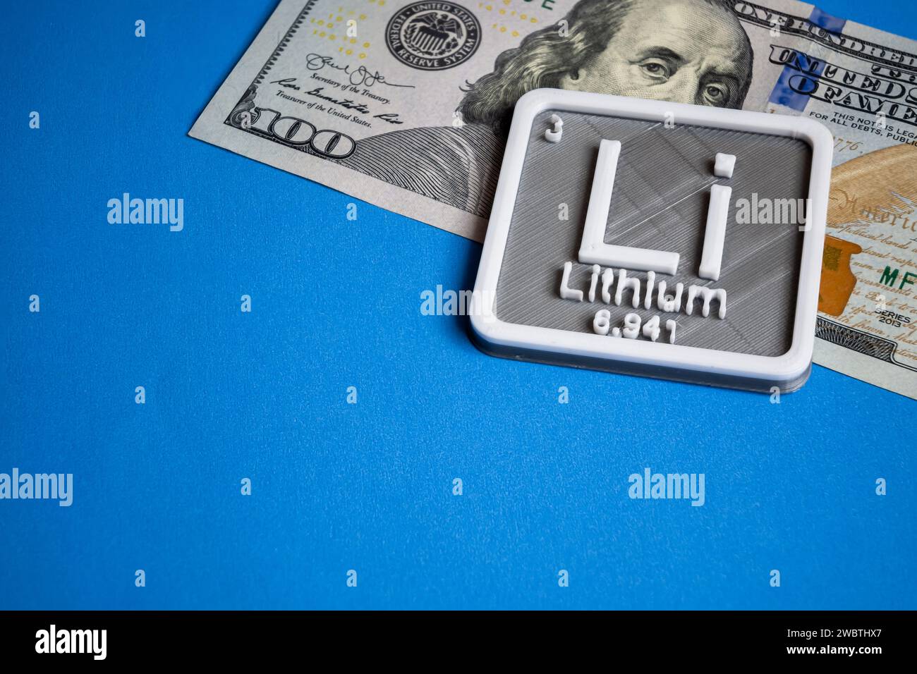 Lithium concept with a hundred dollar bill on a light blue background. Stock Photo