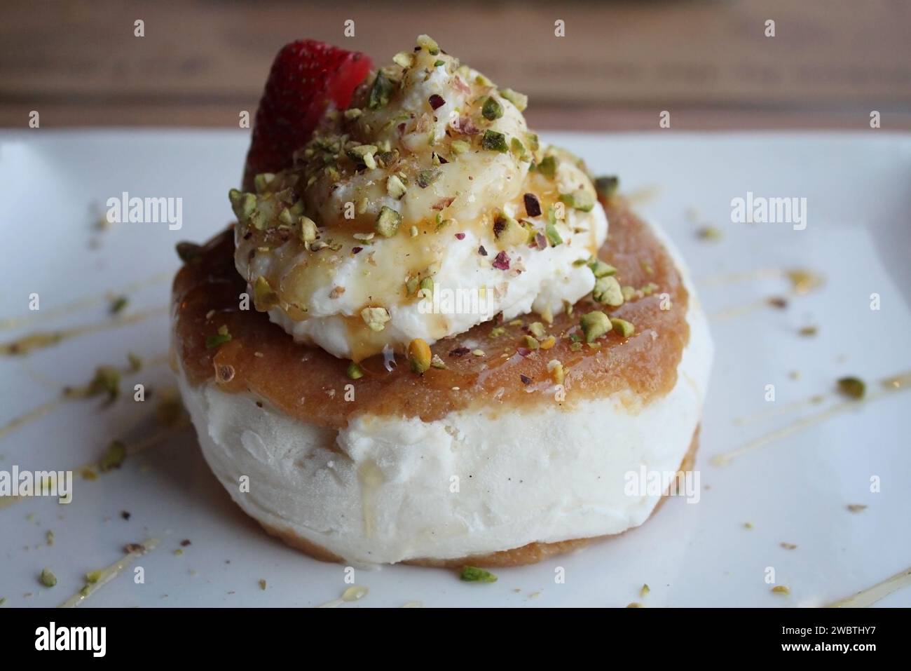 A Lebanese dessert with ashta and vanilla ice cream with pistachios drizzled with honey. Stock Photo