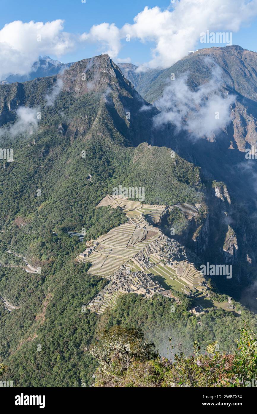 A view of Machu Picchu from the top of Huayna Picchu mountain peak on a clear sunny day in the Sacred Valley in Peru Stock Photo