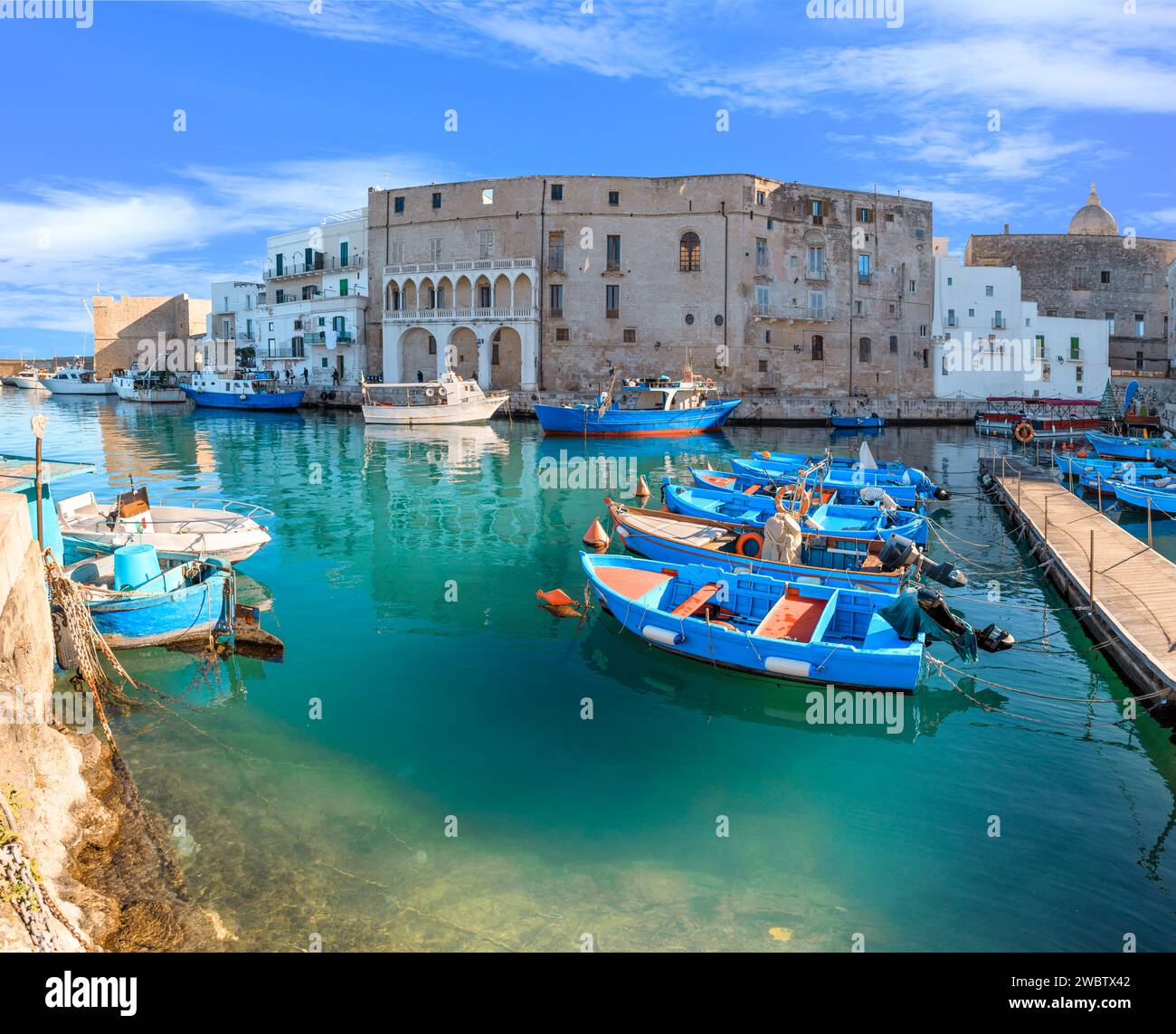 Old port of Monopoli in Apulia, southern Italy: view of the old town with fishing and rowing boats. Stock Photo