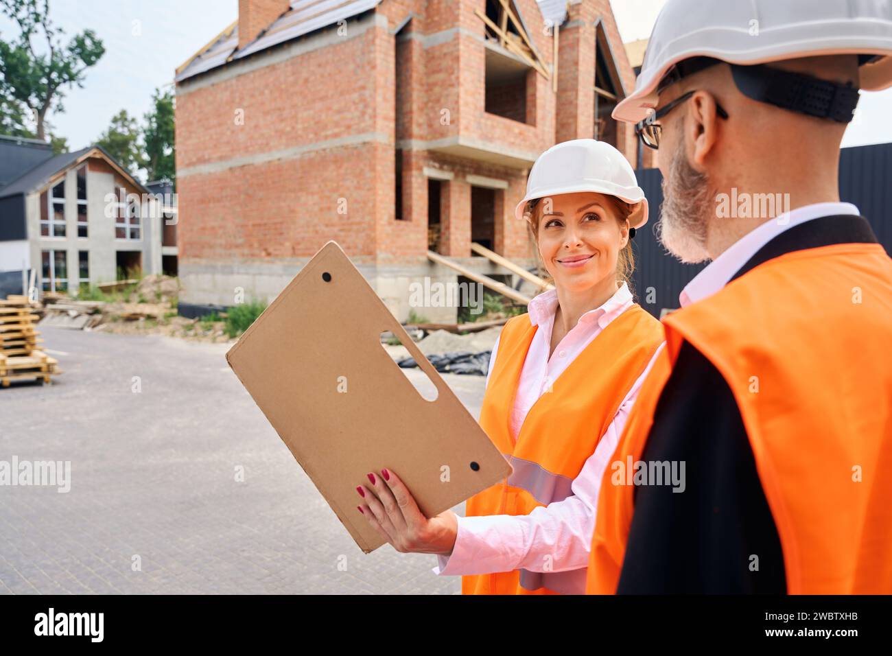 Pleased construction manager showing building documentation to foreman Stock Photo